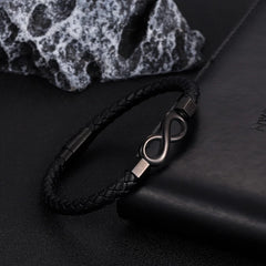 leather bracelet with infinity design styled on desk surface
