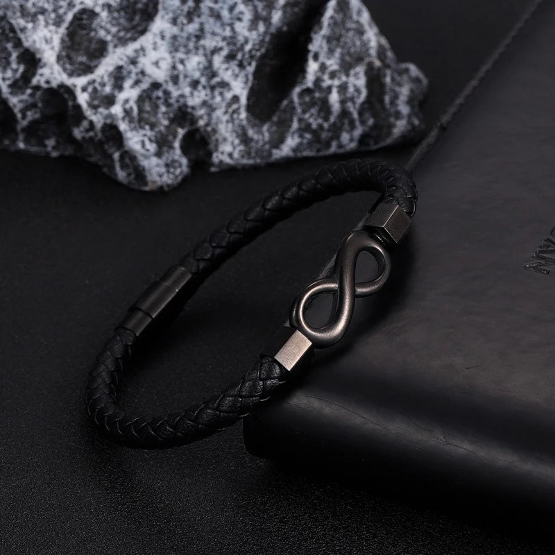 leather bracelet with infinity design styled on desk surface